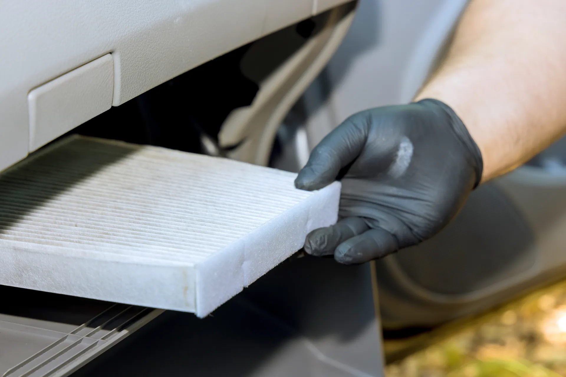 a person inserts a new cabin air filter