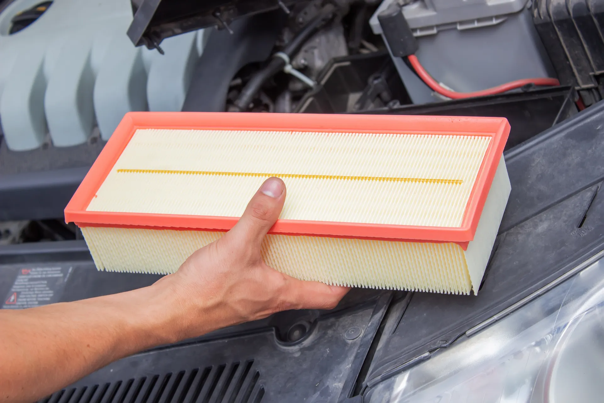 a man installs the new engine air filter