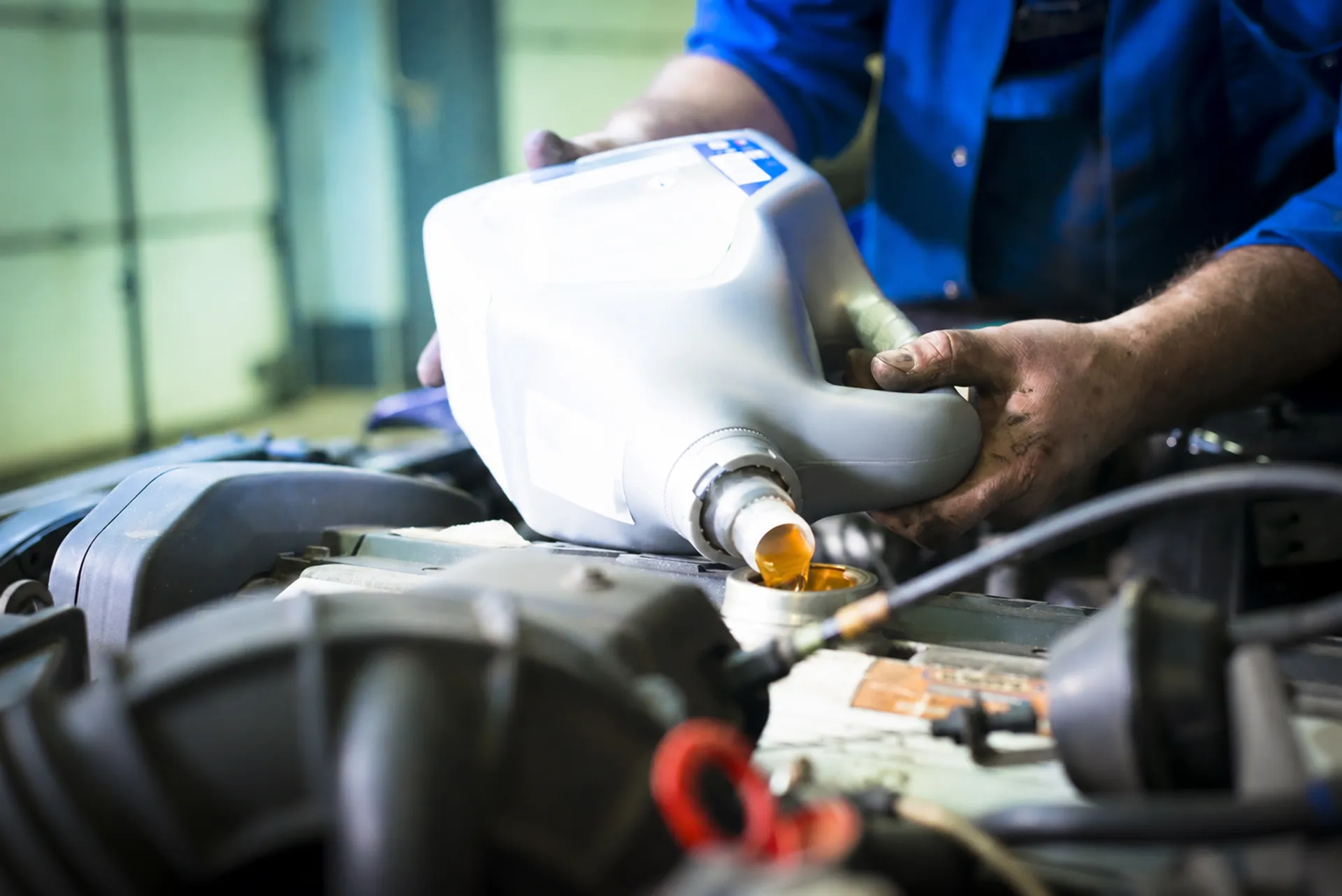 a mechanic adds clean oil