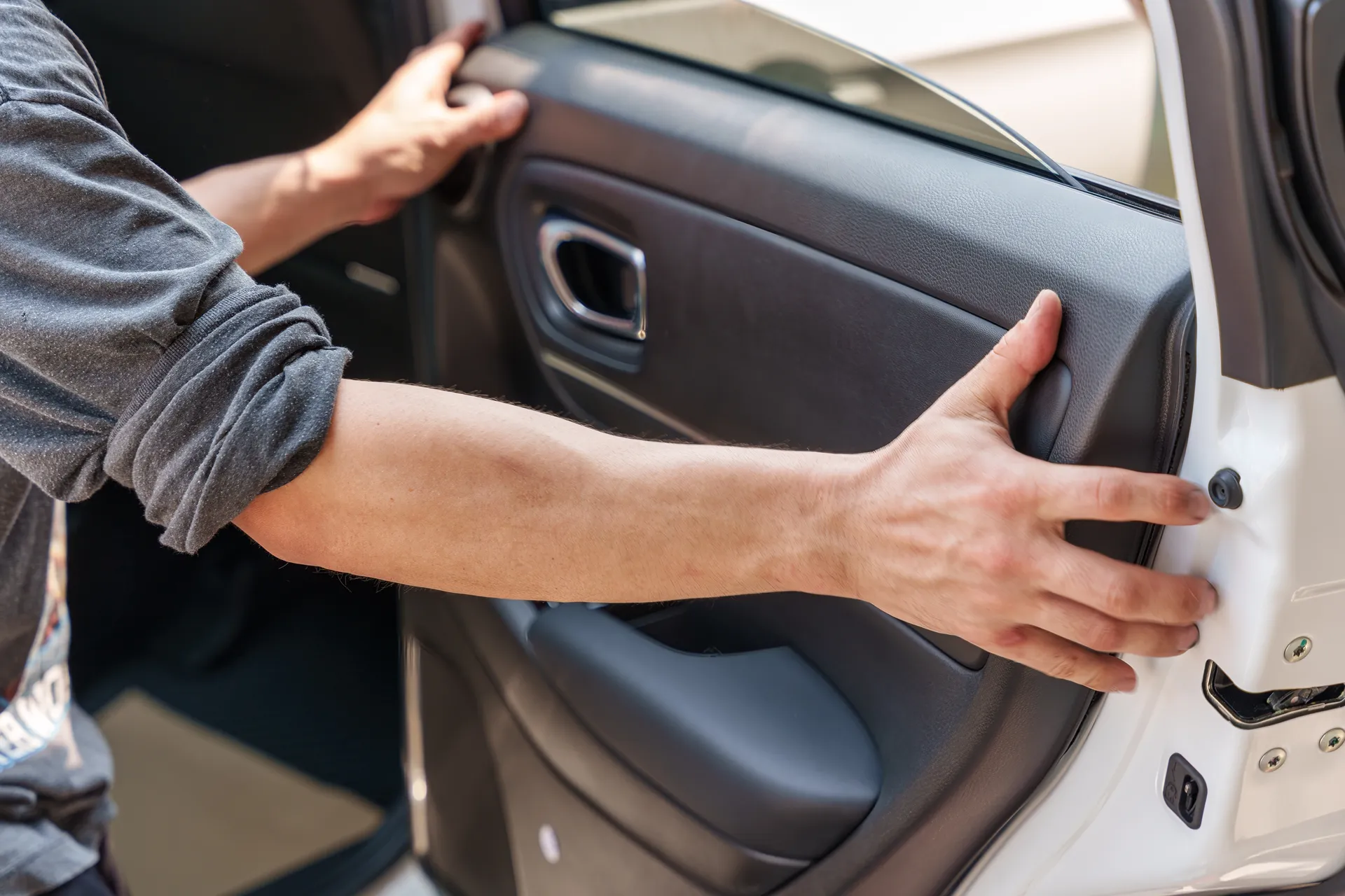 a person reinstalls the door panel after replacing the door lock actuator