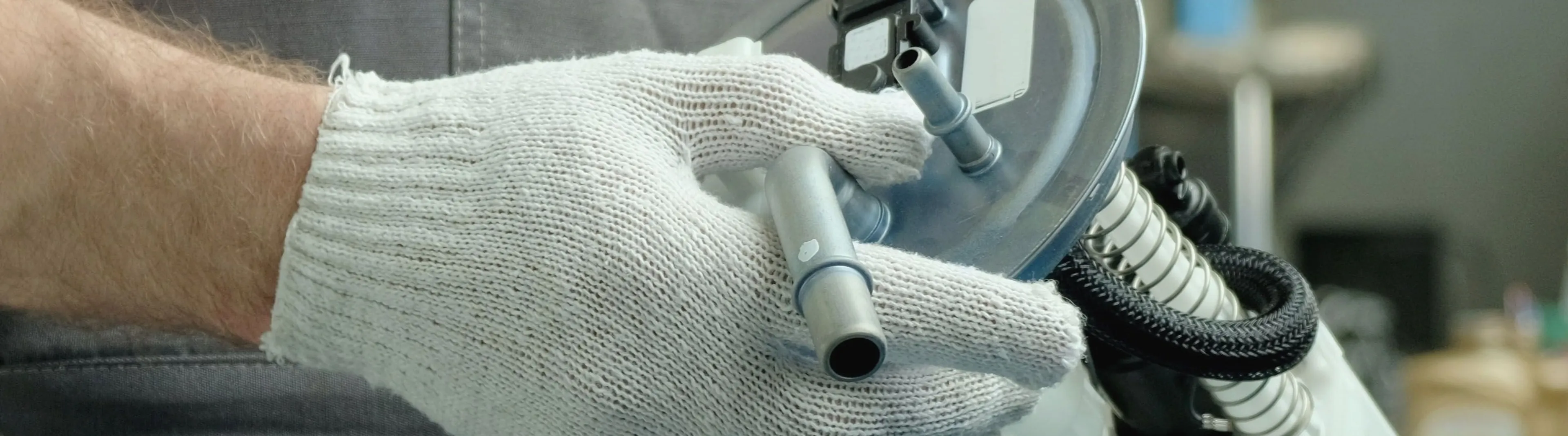 Replacing a car fuel pump: A mechanic holding the fuel delivery unit for installation.